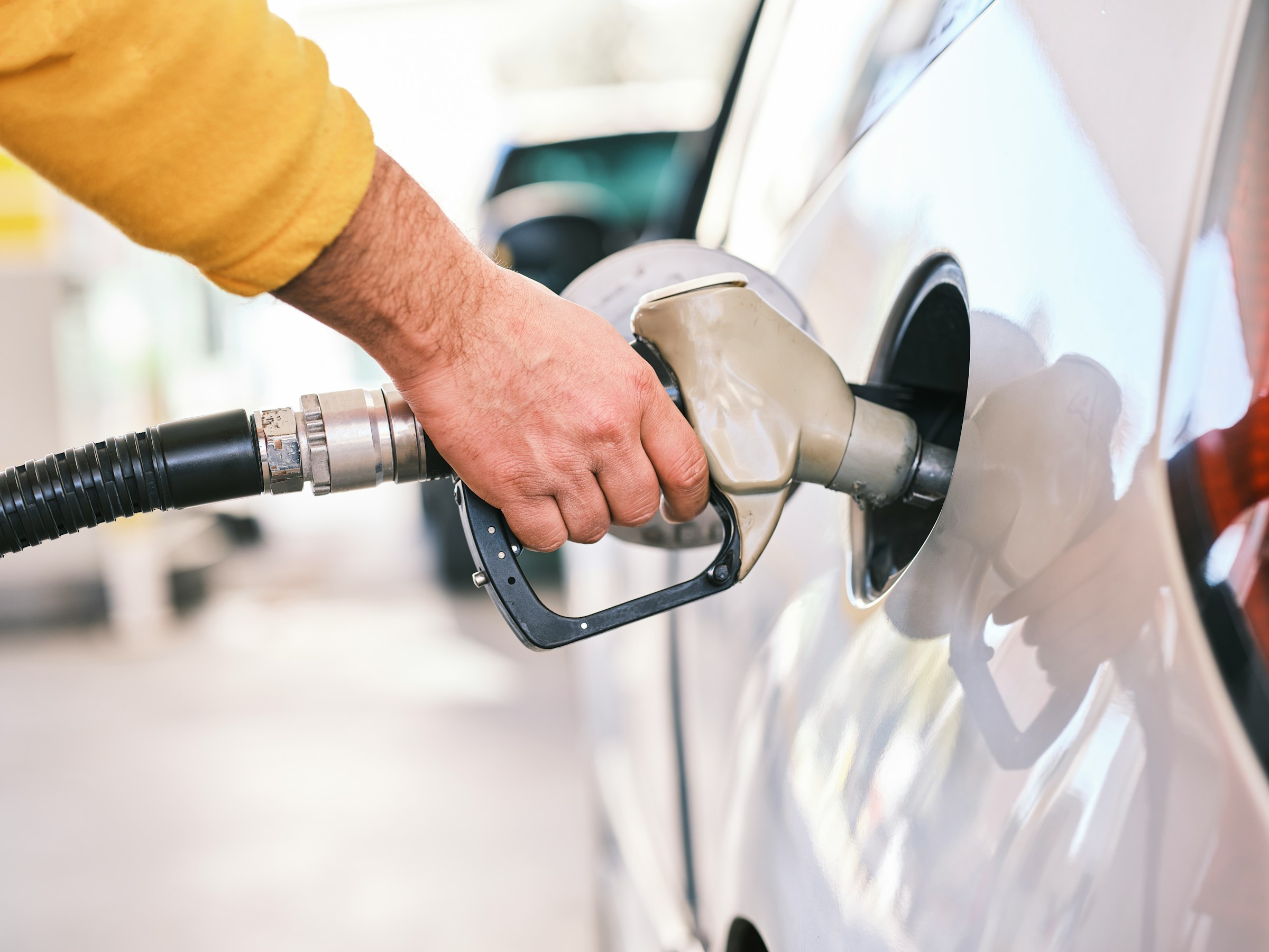 Repostar gasolina Hombre echando gasolina a su coche en una estación de servicio